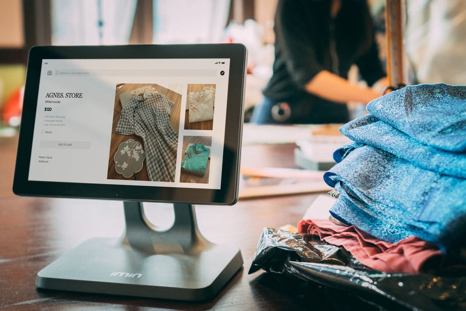 Chủ shop nhỏ đang kiểm tra dữ liệu khách hàng trên máy tính bảng tại cửa hàng